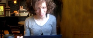 Redheaded transgender blogger Janie Black in a cafe at her notebook computer